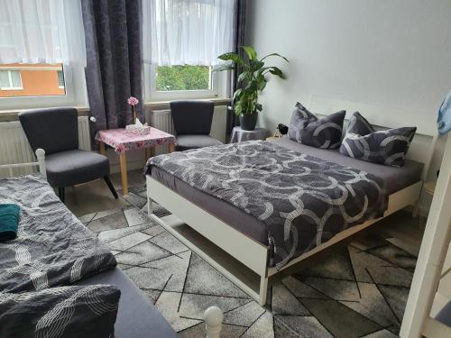 a bedroom with a bed and two chairs and a window at Halle Saale 402 in Ammendorf