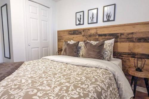 1 dormitorio con 1 cama grande y cabecero de madera en 2 bedrooms apartment with private parking 5 minutes from Montreal, en Longueuil