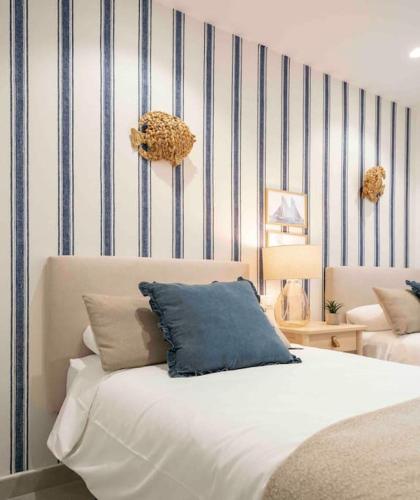 a bedroom with a bed with a blue and white striped wall at Almuñecar Seawiews Deluxe SinEsedesignhomes in Almuñécar