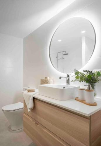 a bathroom with a sink and a toilet and a mirror at Almuñecar Seawiews Deluxe SinEsedesignhomes in Almuñécar