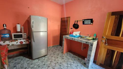 a kitchen with a refrigerator and a counter with a microwave at Casa Coral in Bacalar