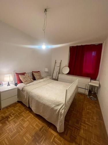 um quarto com uma cama branca e uma janela vermelha em Chez Sophie em Lausanne
