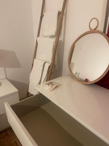 a bathroom with a mirror and a shelf with towels at Chambre Cosy Lausanne in Lausanne