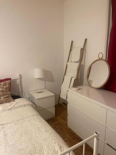 um quarto com uma cama, um espelho e uma cómoda em Chez Sophie em Lausanne