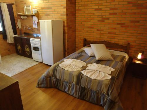 a bedroom with a bed with two towels on it at Pousada Parque da Cachoeira in São Francisco de Paula