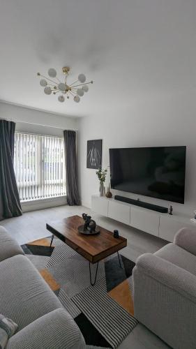 uma sala de estar com uma televisão grande e uma mesa de centro em Kilbelin Abbey em Newbridge