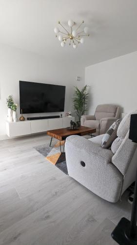 uma sala de estar com um sofá e uma televisão de ecrã plano em Kilbelin Abbey em Newbridge