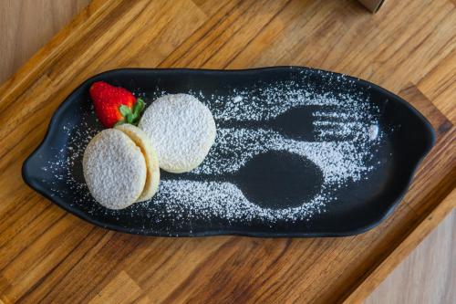 a black plate with two strawberries on a table at Novotel Curitiba Batel in Curitiba