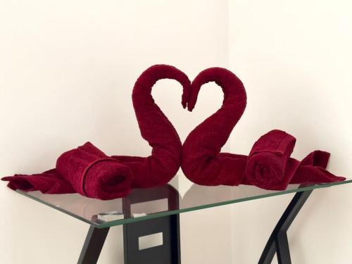 uma mesa de vidro com dois corações tricotados vermelhos em Charmant T5 centre Villeurbanne em Villeurbanne
