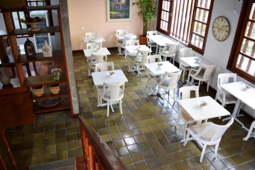 una vista sul soffitto di un ristorante con tavoli e sedie bianchi di Pousada O Garimpo. a Embu