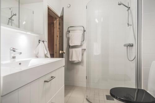 y baño blanco con lavabo y ducha. en Trillevallens Apartments Åre, en Trillevallen