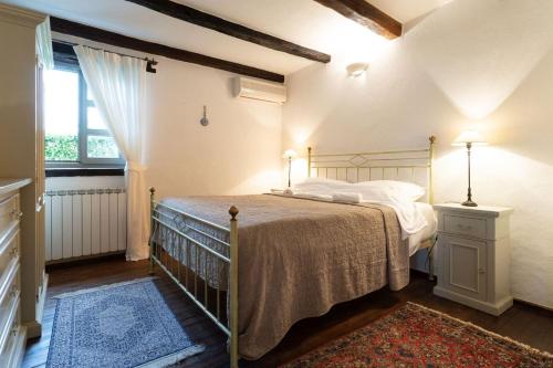 a bedroom with a bed and a window at Rustic villa Amyra with pool and grill in Porec in Sveti Lovreč Pazenatički