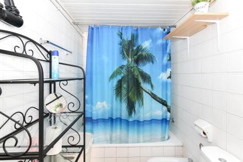 a bathroom with a shower curtain with a palm tree at Apartamento Disa in Lloret de Mar