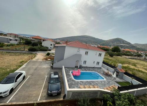 a villa with a pool and two cars parked in a parking lot at Villa Felicita in Trogir
