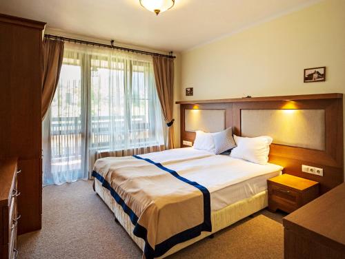 a hotel room with a bed and a large window at 7 Pools SPA Boutique Hotel in Bansko