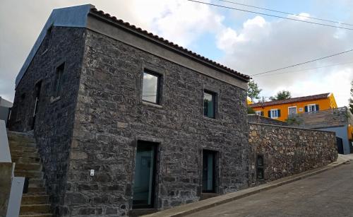 a stone house with a black roof at Ninho do Sonho in Bretanha