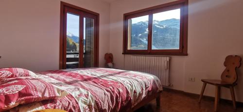 a bedroom with a bed and a window with mountains at Appartamento con splendida vista su pista Stelvio in Bormio