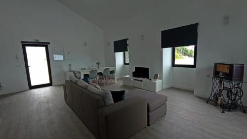 a living room with a couch and a tv at Ninho do Sonho in Bretanha