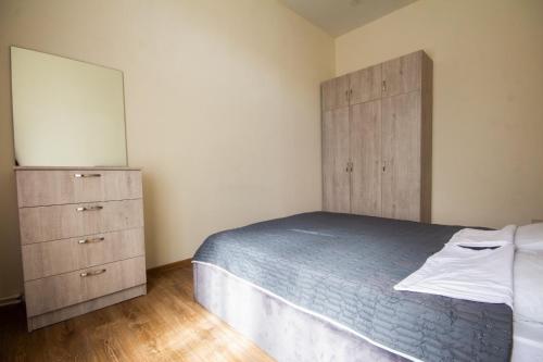 a bedroom with a bed and a dresser and a mirror at Center Apartment 3 Rooms in Tbilisi City
