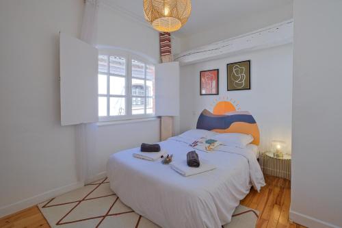 - une chambre avec un grand lit blanc et 2 téléphones dans l'établissement Numéro 6 - Place Nationale - Wifi et Fibre, à Montauban