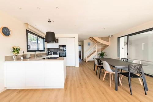 a kitchen and dining room with a table and chairs at La Pointe sur l'eau - Vue mer - Piscine intérieure in Plougastel-Daoulas