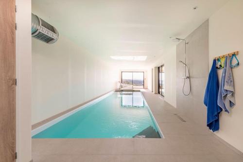 een zwembad in het midden van een kamer bij La Pointe sur l'eau - Vue mer - Piscine intérieure in Plougastel-Daoulas
