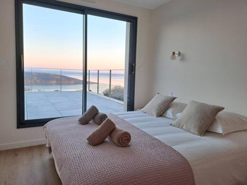 deux lits dans une chambre avec une grande fenêtre dans l'établissement La Pointe sur l'eau - Vue mer - Piscine intérieure, à Plougastel-Daoulas