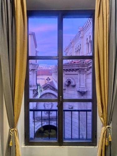 una vista di un edificio attraverso una finestra di Loft Paradis - Hyper Centre - 280M2 a Marsiglia