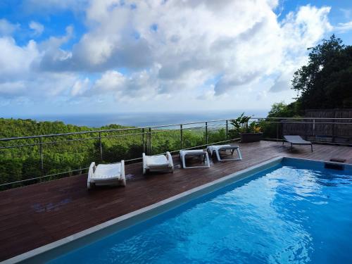 a swimming pool with two lounge chairs next to at Villa Madjic in Sainte-Luce