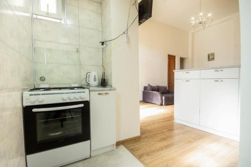 a kitchen with a stove and a white refrigerator at Center Apartment 3 Rooms in Tbilisi City