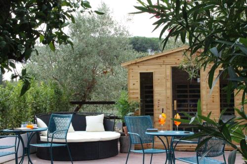 a patio with a couch and two tables and a shed at Giardini Penelope Resort e Spa in Ciampino
