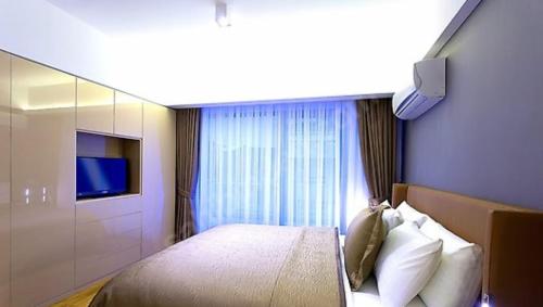 1 dormitorio con 1 cama grande y TV en Elif, en Beylikduzu