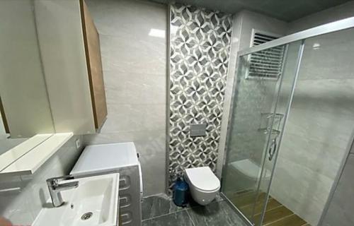 uma casa de banho com um chuveiro, um WC e um lavatório. em Elif em Beylikdüzü