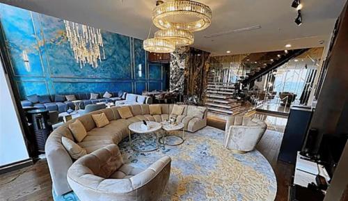 uma sala de estar com um sofá grande e um lustre em Elif em Beylikdüzü