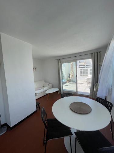 un salon avec une table et des chaises blanches dans l'établissement Vue Mer - Calme et lumineux, à Marseille