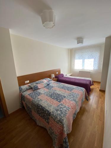een slaapkamer met 2 bedden en een raam bij dp Calvo Sotelo 164, 4C in Sarria