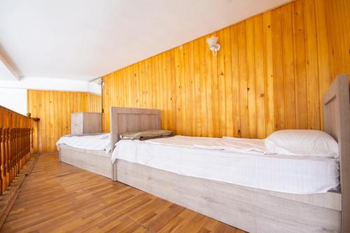 two beds in a room with wooden walls at Center Apartment 3 Rooms in Tbilisi City