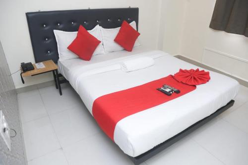 1 dormitorio con 1 cama grande con almohadas rojas en Hotel Leesha Residency, en Kalyan