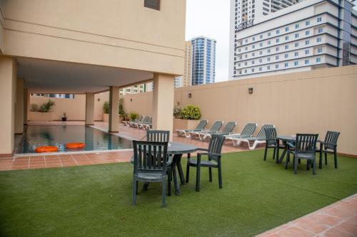 un patio con mesa, sillas y piscina en Juffair Trends Luxury Apartment, en Juffair