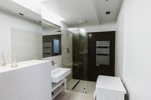 Baño blanco con lavabo y espejo en Yourplace Central Apartments, en Cracovia