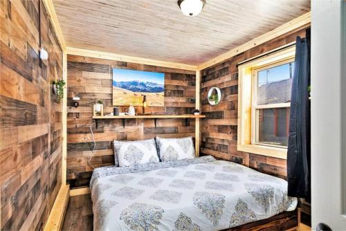 1 dormitorio con 1 cama en una habitación con paredes de madera en Dog Friendly Private Cabin w Hot Tub Leadville-A, en Leadville