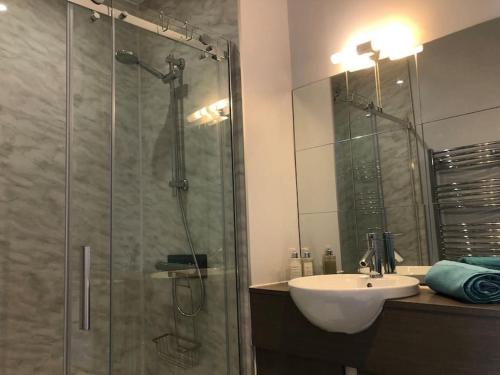 a bathroom with a glass shower and a sink at 2 Bedroom cottage with Beautiful views over the Mendips in Radstock