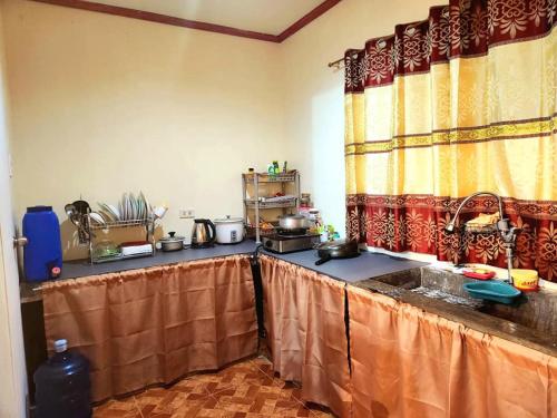 a kitchen with a table with a counter top at Joi's Entire House @ Lessandra Gran Europa Lumbia in Cagayan de Oro