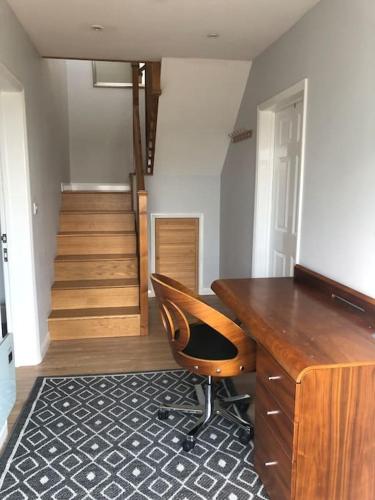 a room with a desk and a chair and stairs at 2 Bedroom cottage with Beautiful views over the Mendips in Radstock