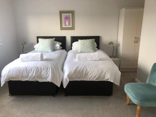 two beds sitting next to each other in a bedroom at 2 Bedroom cottage with Beautiful views over the Mendips in Radstock