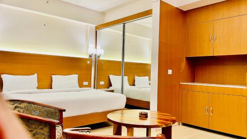 ラクナウにあるNeel Skye - Couple Friendly - DLF My Pad, Gomtinagar , Lucknowのベッドとテーブルが備わるホテルルームです。