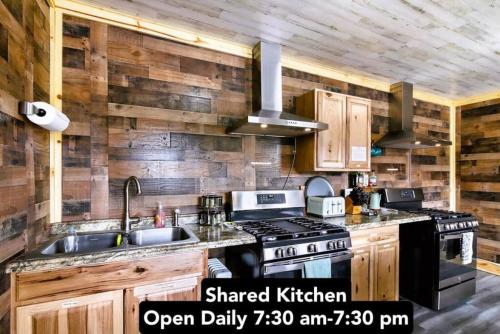 a kitchen with wooden walls and a stove and a sink at 8 Private room in heart of Leadville dog friendly in Leadville