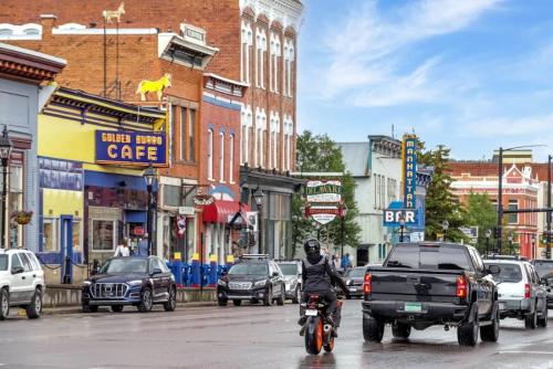 a man riding a motorcycle down a busy city street at 8 Private room in heart of Leadville dog friendly in Leadville