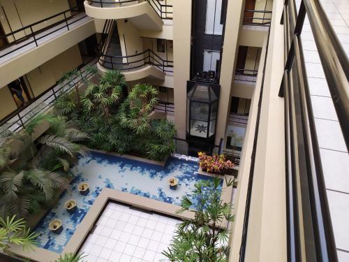 an overhead view of a building with a swimming pool and palm trees at Studio do Bosque in Curitiba