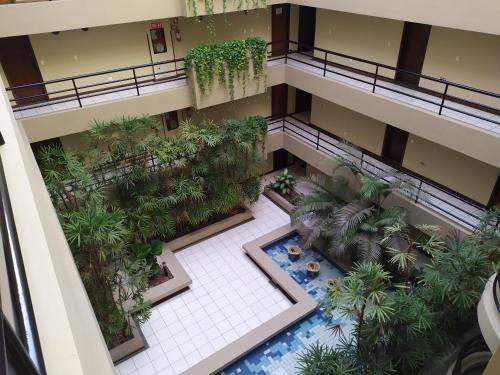 - une vue sur un bâtiment doté d'une piscine et de palmiers dans l'établissement Studio do Bosque, à Curitiba